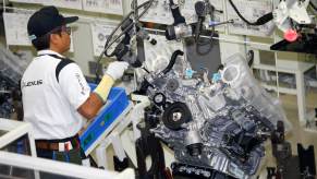 A Lexus factory worker works on a Lexus V8 engine