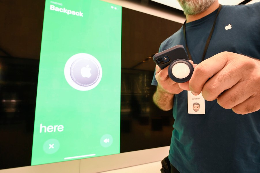 A man scans an Apple Airtag next to an Apple store.