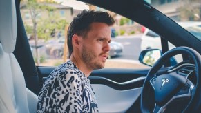 Man sitting in Tesla, highlighting if you can get DUI if drunk in Tesla Autopilot, FSD, or self-driving car