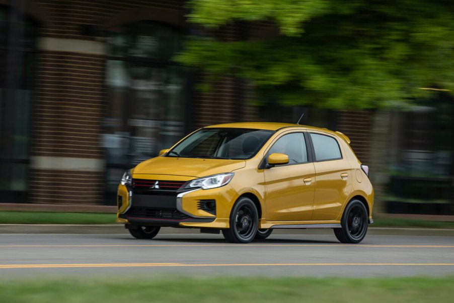 A Mitsubishi Mirage hatchback driving down the road.