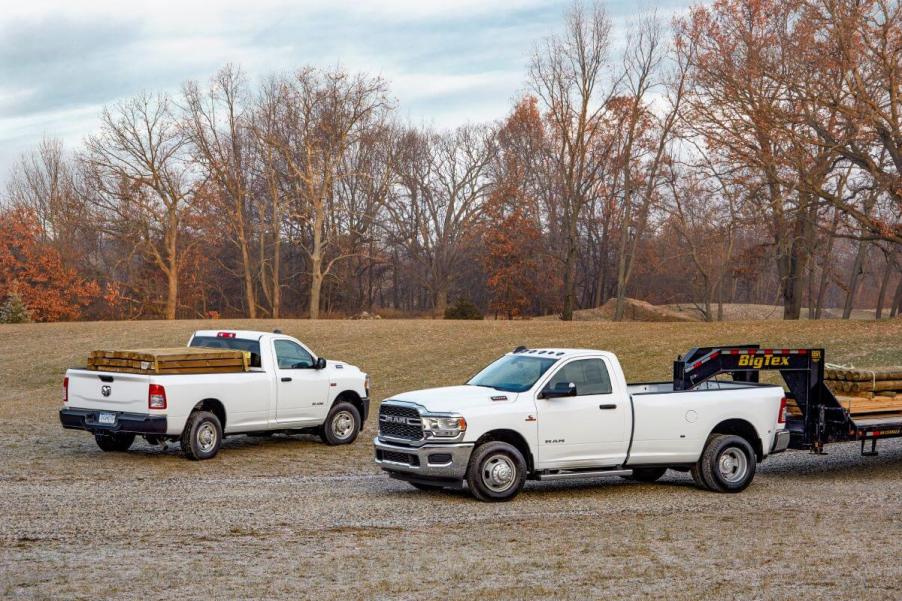 A pair of white Ram 2500 and 3500 heavy-duty (HD) Tradesman models working in a forest plain