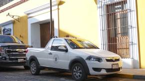 A white, two door Ram 700 compact truck parked on the street in Mexico.