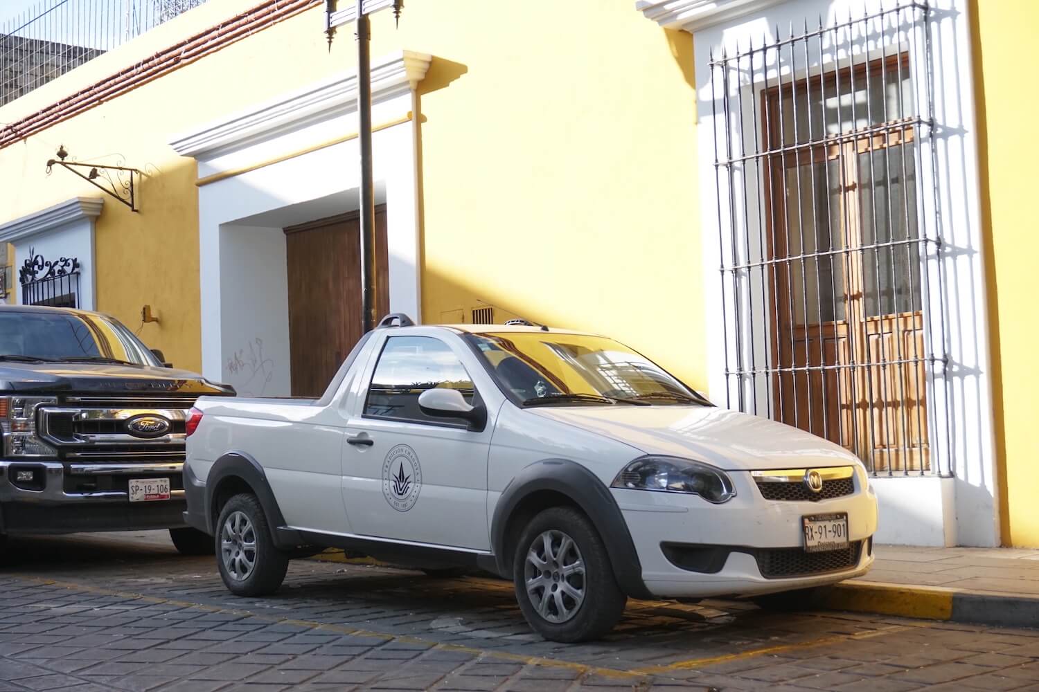 A white, two door Ram 700 compact truck parked on the street in Mexico.