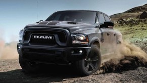 A grey 2023 Ram 1500 Warlock kicks up dirt.