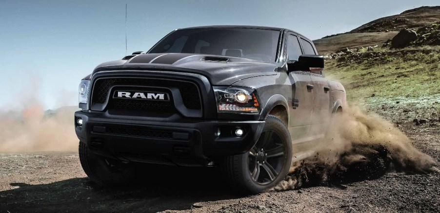 A grey 2023 Ram 1500 Warlock kicks up dirt.