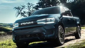 The Ram 1500 REV drives on a dirt road as an electric truck.