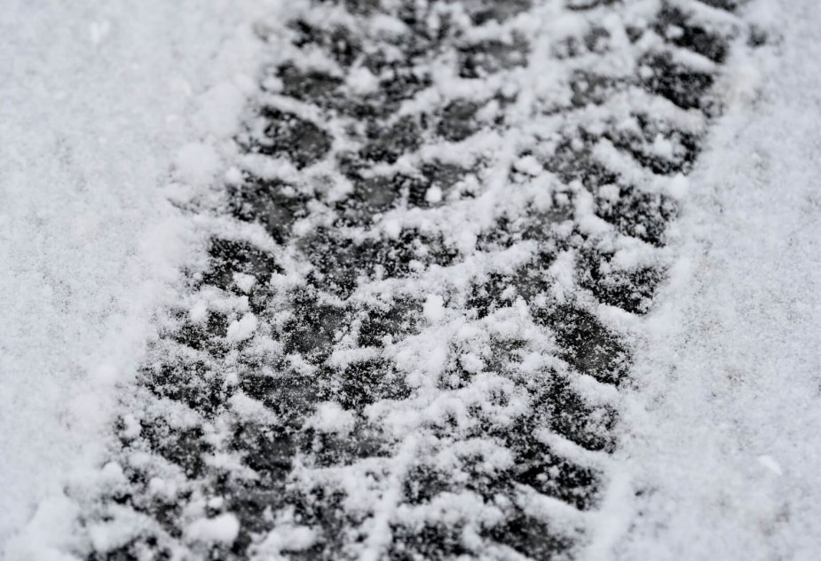 Close up of a tire print in fresh snow.