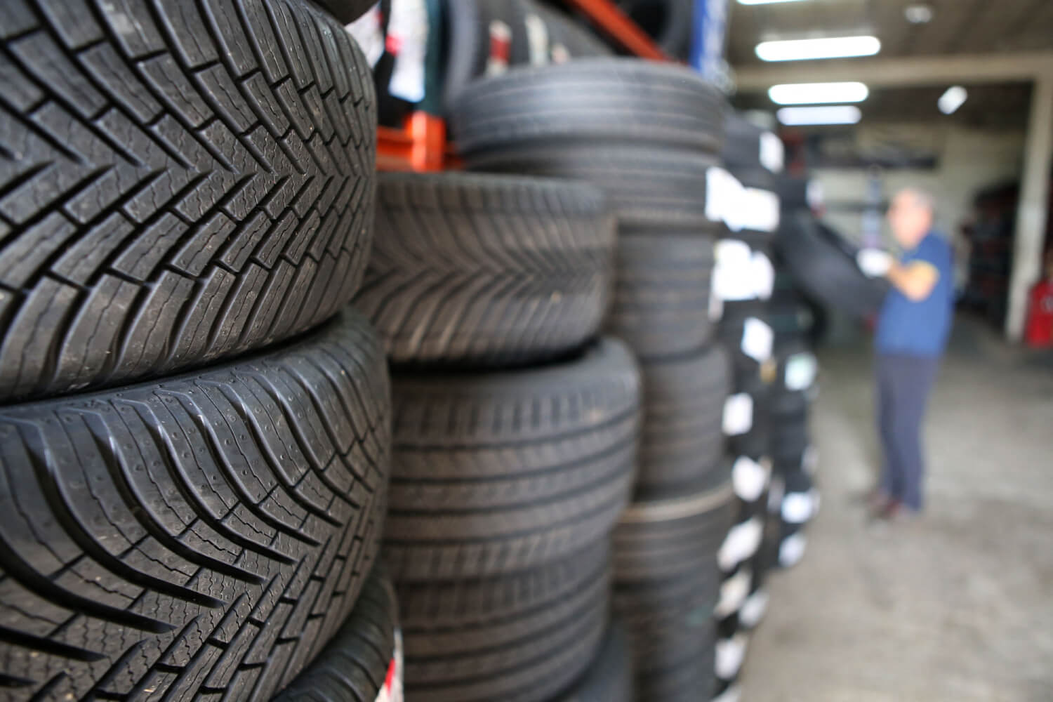 Winter tires ready for use on SUVs sit stacked in indoor storage.