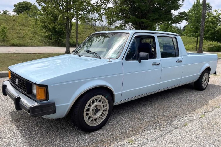 Closeup of the fender of a blue VW rabbit pickup truck modified to have four doors.