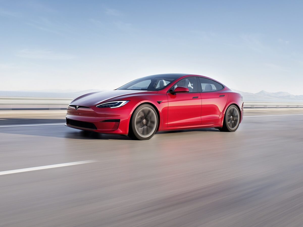 A 2023 Tesla Model S safely blasts down a desert road.