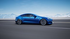 A bright blue Tesla Model S Plaid displays its profile on a test track.