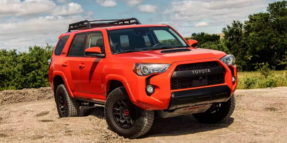 An orange 2023 Toyota 4Runner midsize SUV is parked outdoors. 