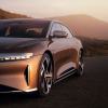 A Lucid Air luxury electric car driving down a road.