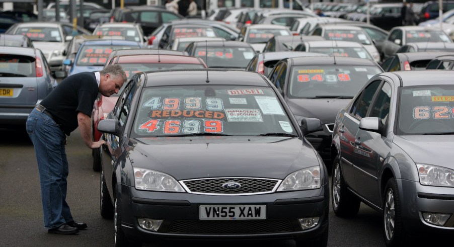 A used car shoppers looks at used cars on a lot