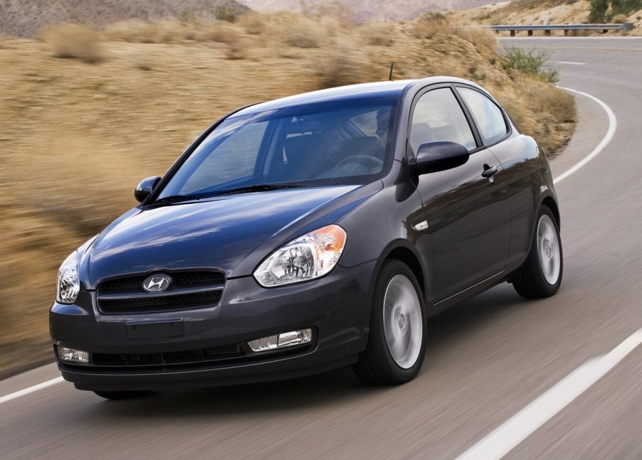 A gray 2010 Hyundai Accent shows off its small car proportions that makes it one of the best used cars on a country road.