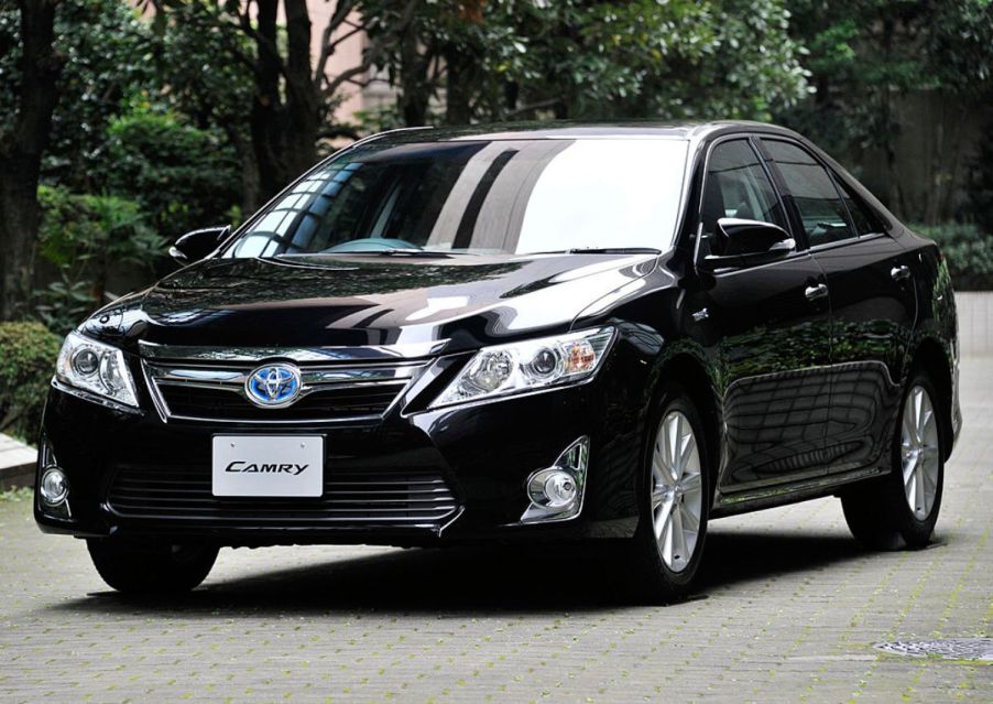 A 2011 Toyota Camry Hybrid driving down the road.