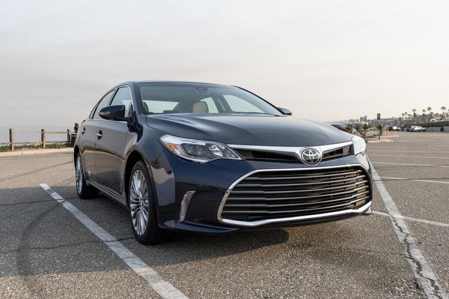 A used blue 2016 Toyota Avalon parks in an open lot.