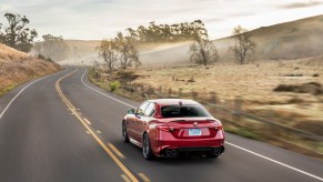 A red 2017 Alfa Romeo Giulia Quadrifoglio cruises down a back road.