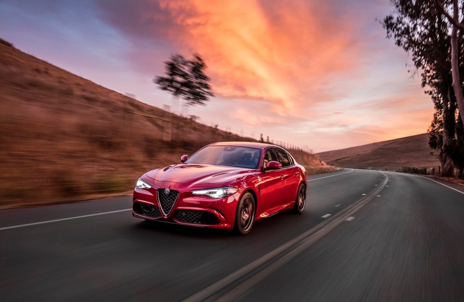 A used 2017 Alfa Romeo Giulia Quadrifoglio corners under a sunset.