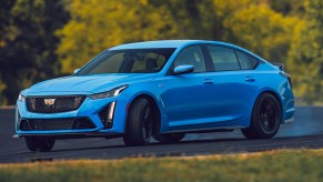 A blue Cadillac CT5 V Blackwing sliding at a racetrack