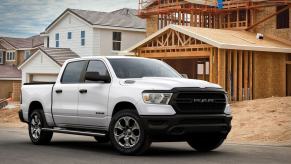 A white 2022 Ram 1500 Tradesman EcoDiesel full-size pickup truck work model outside a home construction site