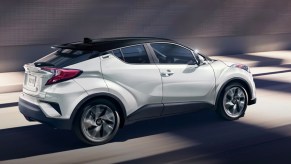 A white 2022 Toyota C-HR subcompact SUV is driving.