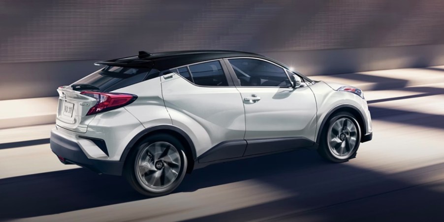 A white 2022 Toyota C-HR subcompact SUV is driving.