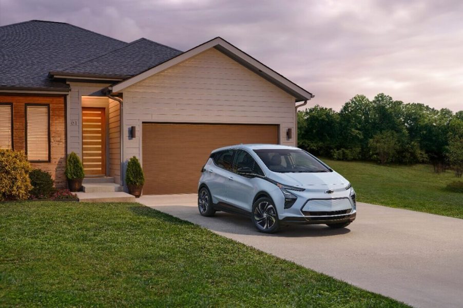 GM (General Motors) smallest EV, the Chevy Bolt EV, poses by a garage.