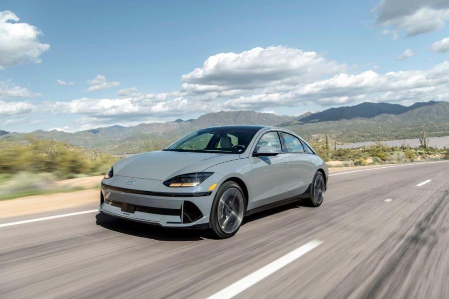 A slate-gray 2023 Hyundai Ioniq 6 midsize electric fastback sedan model driving down a desert highway road