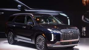 A black 2023 Hyundai Palisade parked indoors.