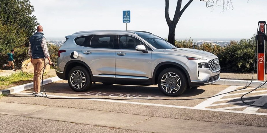 A gray 2023 Hyundai Santa Fe Plug-In Hybrid is parked and charging. 