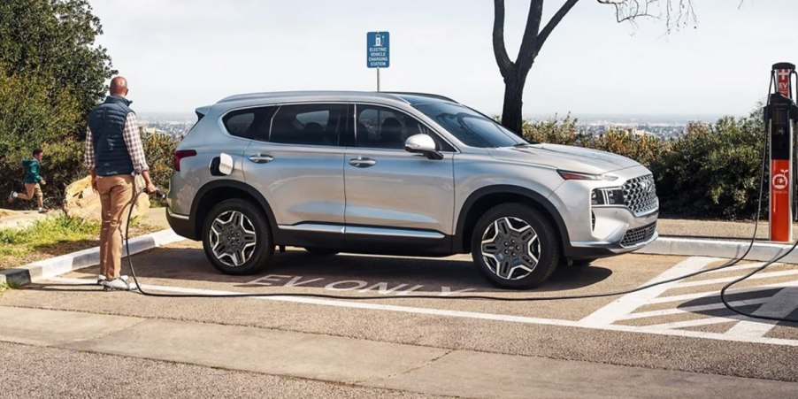 A gray 2023 Hyundai Santa Fe Plug-In Hybrid small PHEV SUV is parked and charging.