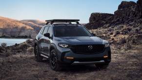 A dark color 2023 Mazda CX-50 parked in a desert area.