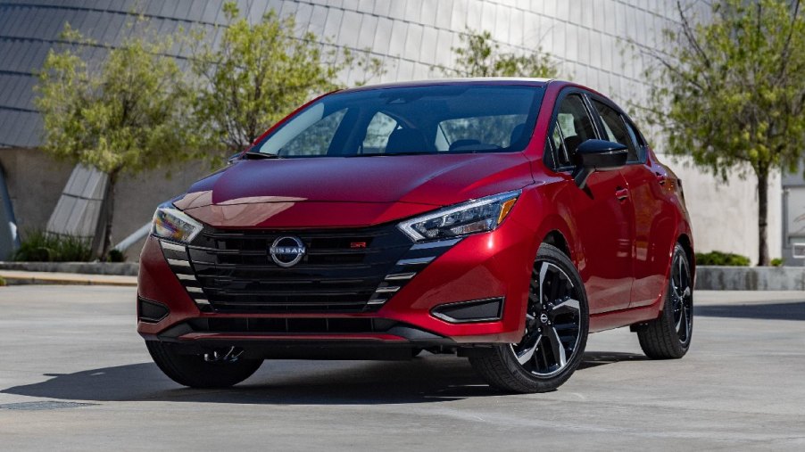 2023 Nissan Versa, cheapest new car in 2023, not a Toyota or Honda, parked in front of building