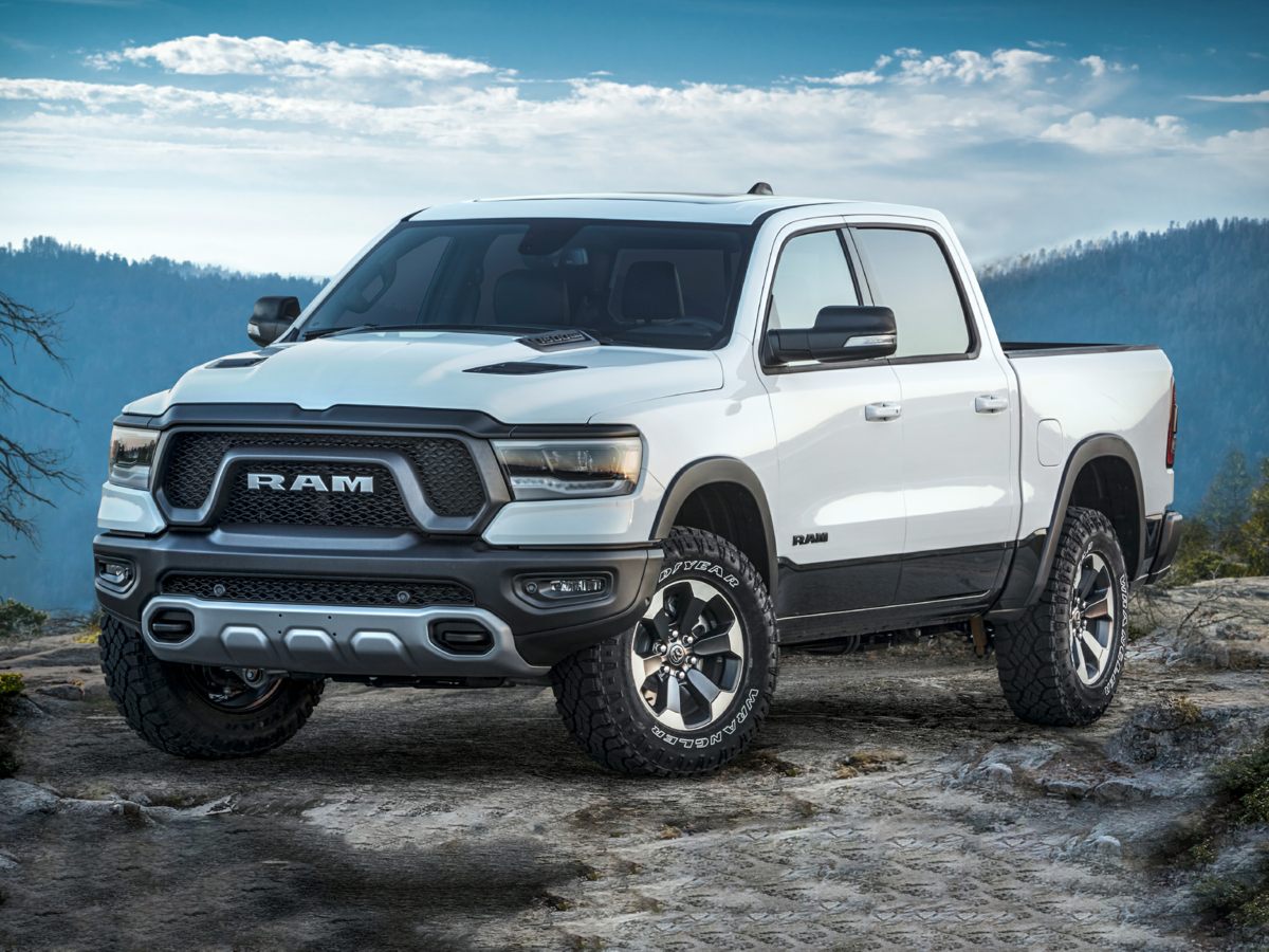 A white 2023 Ram 1500 parked on an rock.