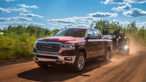 Red 2023 Ram 1500 pickup truck pulling a trailer.