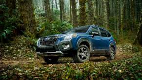 A blue 2023 Subaru Forester parked outdoors in a wooded area. The Crosstrek, not the Forester, is now the most popular Subaru model.