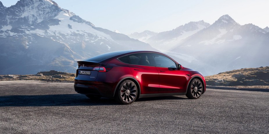 A red 2023 Tesla Model Y small electric SUV is parked. 