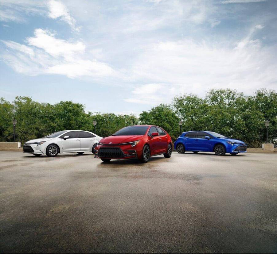 A trio of 2023 Toyota Corolla AWD Hybrids and Hatchbacks poses in a park.