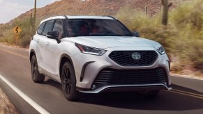 2023 Toyota Highlander midsize SUV driving on a desert highway