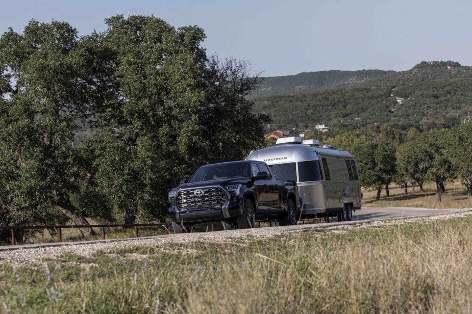 A Toyota Tundra in the distance hooked up to an airstream travel trailer, trees visible in the background.