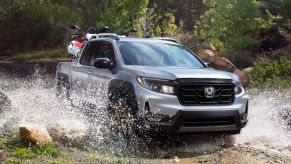 A 2023 Honda Ridgeline is driving through water as a midsize truck.