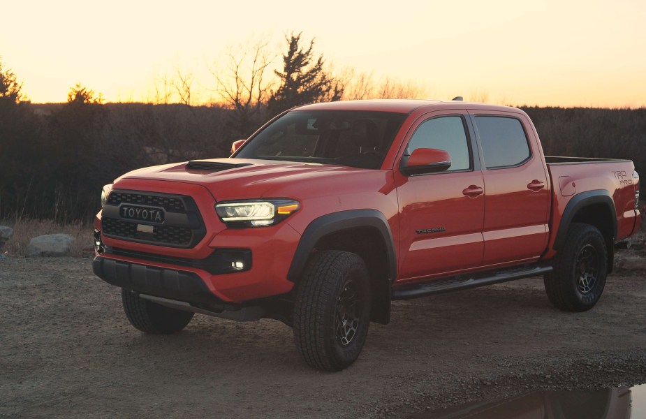 A red 2023 Toyota Tacoma TRD Pro midsize truck sits at sunset.