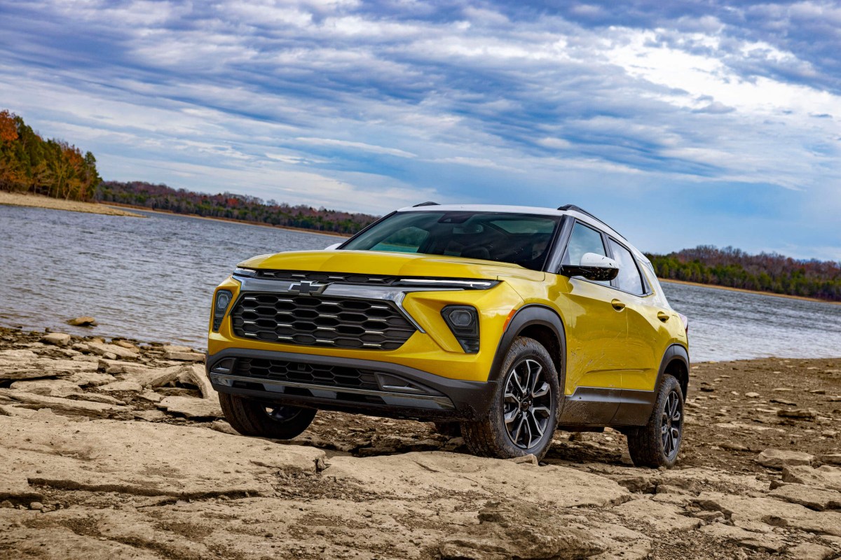 Front 3/4 view of 2024 Chevy Trailblazer ACTIV in Copper Harbor Metallic parked on a rock bank in front of a lake. Preproduction model shown. Actual production model may vary. Available in fall 2023.