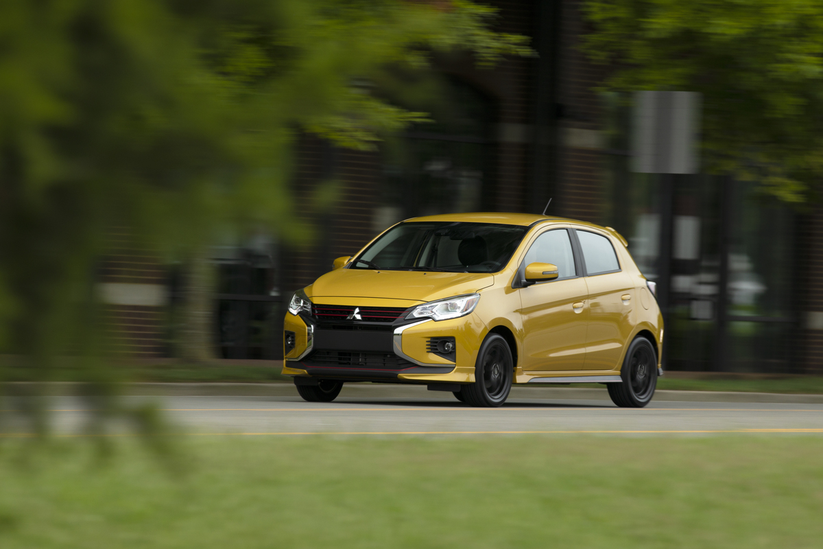 A yellow Mitsubishi Mirage driving