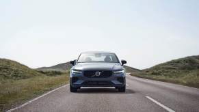 A gray Volvo S60 drives toward the camera.