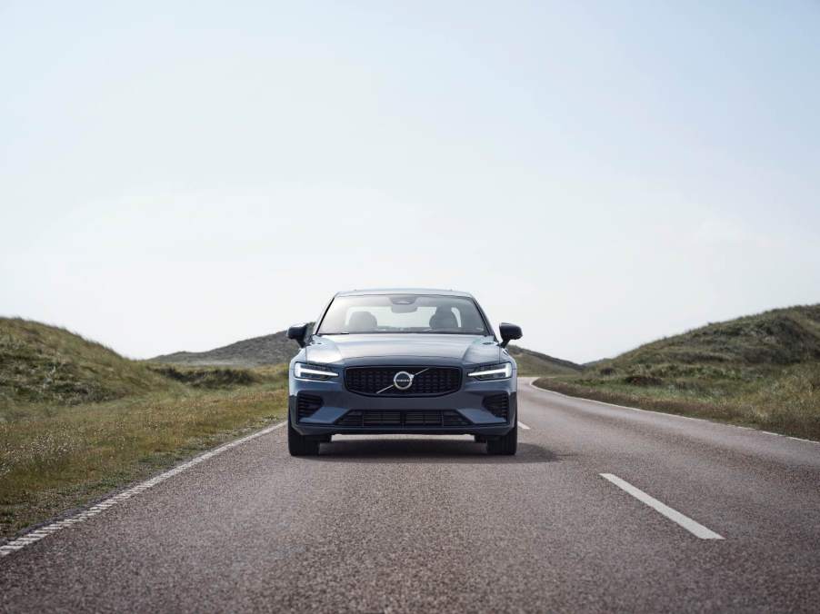 A gray Volvo S60 drives toward the camera.