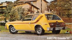 A yellow AMC Gremlin shown on a postcard.