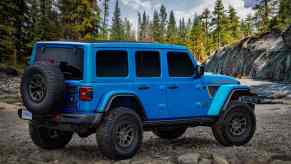 Rear view of a Jeep Wrangler Rubicon, ranked among the best SUVs for tall people, in an alpine forest.