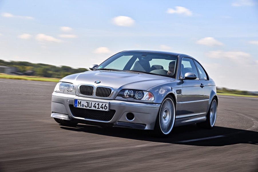 A silver BMW E46 M3 blasts across a track.